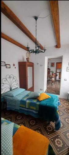 a bedroom with two beds and a chandelier at Casa Bella 'Mbriana in Rio Marina