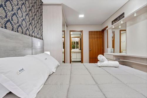 - une chambre avec un grand lit et un miroir dans l'établissement Flores da Montanha Centro by Achei Gramado, à Gramado