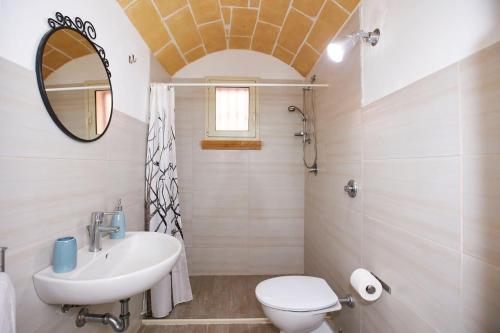 ein Badezimmer mit einem Waschbecken, einem WC und einem Spiegel in der Unterkunft La casa di Marilù in Marsala