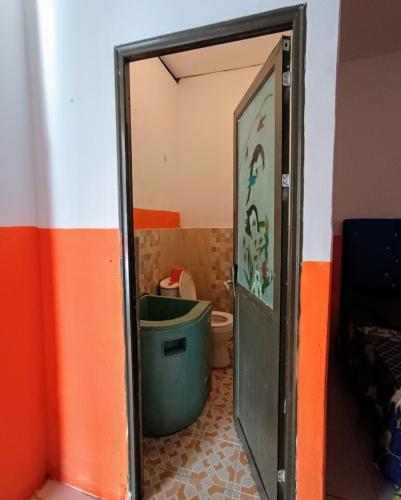 a bathroom with a toilet and a mirror at Orion Jaya Kost in Ketapang