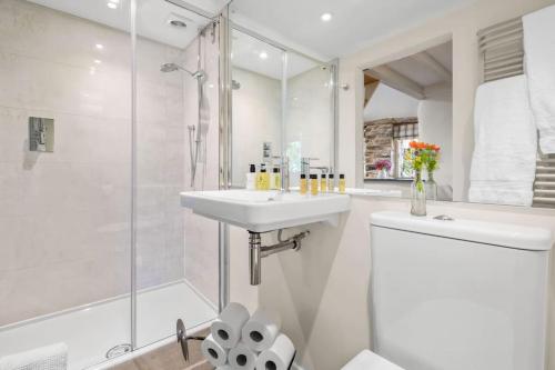 a white bathroom with a sink and a shower at Luxury self-contained cottage for two with hot tub in Staverton