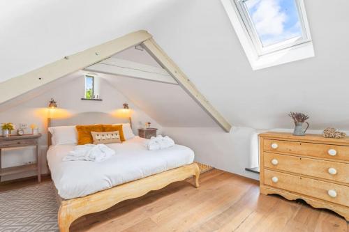 a bedroom with a white bed and a dresser at Luxury self-contained cottage for two with hot tub in Staverton