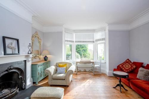 sala de estar con chimenea y sofá rojo en Phoenix Rise Retreat en Glastonbury