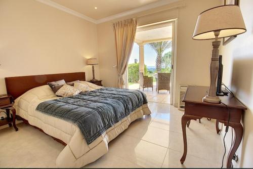 une chambre avec un lit et une table avec une lampe dans l'établissement Superbe Villa avec vue mer panoramique - Villa Chelsea, à Sainte-Maxime