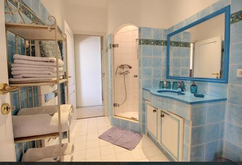 une salle de bain carrelée bleue avec un lavabo et une douche dans l'établissement Superbe Villa avec vue mer panoramique - Villa Chelsea, à Sainte-Maxime