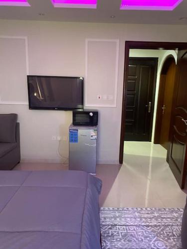 a living room with a couch and a flat screen tv at يقع المسكن في مدينة جدة الساحليه in Ḩayy al Ḩamdānīyah