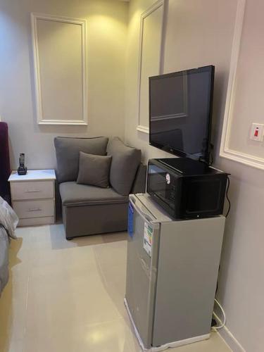 a living room with a couch and a flat screen tv at يقع المسكن في مدينة جدة الساحليه in Ḩayy al Ḩamdānīyah