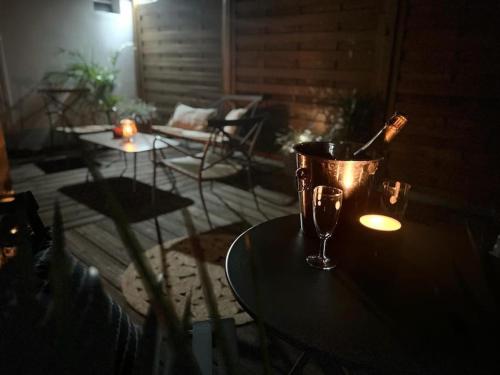 a table with a bucket and a wine glass on it at Le Pluméria - T1 avec un SPA privatif in Saint-Denis