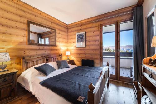1 dormitorio con 1 cama en una habitación con paredes de madera en Résidence Balcons De Pralong - 4 Pièces pour 6 Personnes 064, en Courchevel