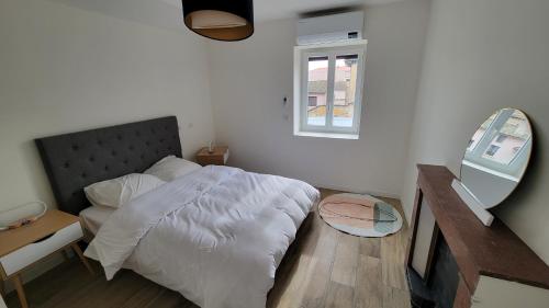 a bedroom with a bed and a desk and a mirror at Appartement neuf avec terrasse in Montmerle Sur Saône