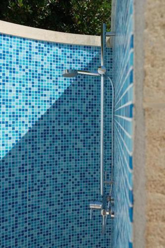 a blue tiled swimming pool with a street light at Villa Antares by LoveSud in Marina di Pescoluse