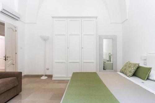 a white room with a bed and a couch at Villa Antares by LoveSud in Marina di Pescoluse