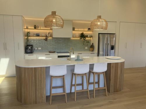 a kitchen with a large island with bar stools at Mountain Views, Remarkable in Queenstown