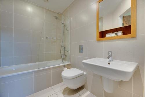 a bathroom with a sink and a toilet and a bath tub at Fenwick Chambers by Week2Week in Gosforth
