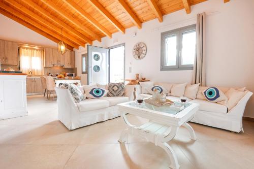 uma sala de estar com mobiliário branco e uma mesa em Villa Theoni em Sami