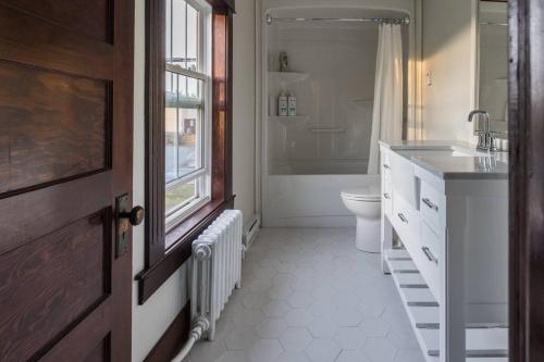a bathroom with a sink and a toilet and a window at Duff Heritage House in St. John's