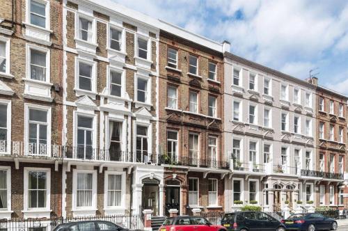 a large building with cars parked in front of it at Coronation Hotel in London