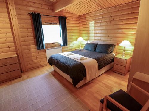 ein Schlafzimmer mit einem Bett in einer Holzhütte in der Unterkunft The Great Escape in Louth
