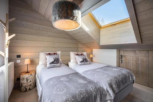 twee bedden in een kleine kamer met een dakraam bij Résidence Parc Alpin - 4 Pièces pour 6 Personnes 354 in Les Allues