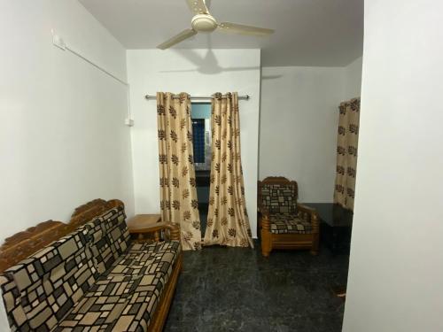 a living room with two beds and a ceiling fan at KOKARI,S HOMESTAY 101 BY AL MANAL in Bhatkal