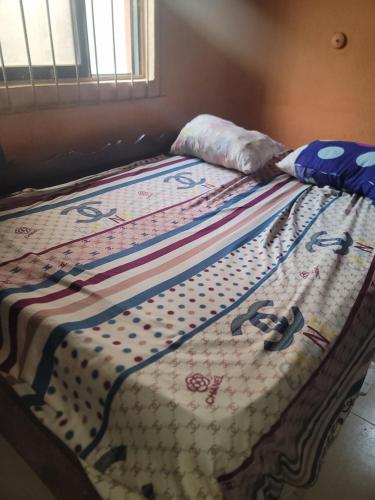 a bed with a quilt on top of it at Tobs home in Lagos