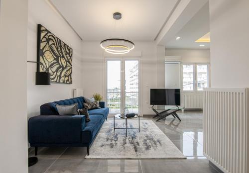 sala de estar con sofá azul y TV en Two Bedroom Sea View Apartment in Glyfada Beach, en Atenas