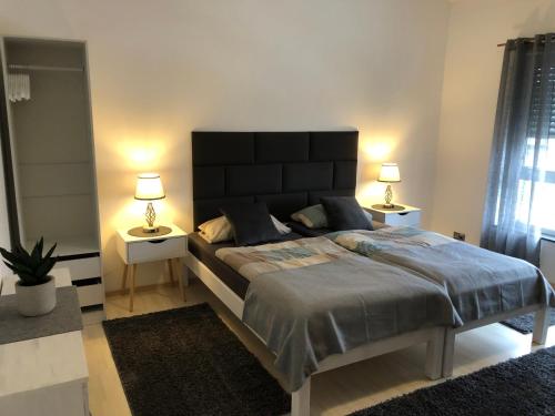 a bedroom with a large bed with two night stands at Pension Am Römerhof in Münzenberg