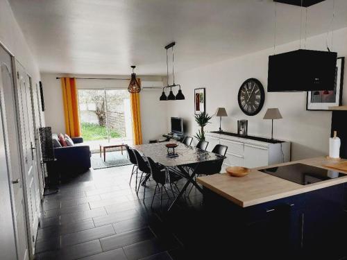 eine Küche und ein Wohnzimmer mit einem Tisch und Stühlen in der Unterkunft CHARMANTE MAISON 4/6 PERSONNES in Saint-Aunès