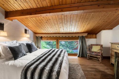 a bedroom with a large bed and a wooden ceiling at Résidence Roc Mugnier - Chalets pour 8 Personnes 504 in Courchevel