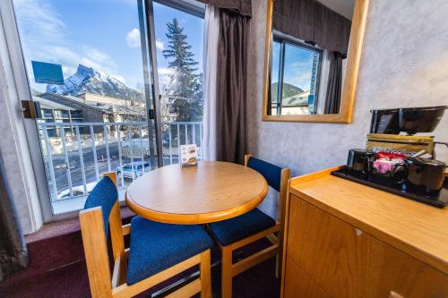 a table and chairs in a room with a large window at Bow View Lodge in Banff