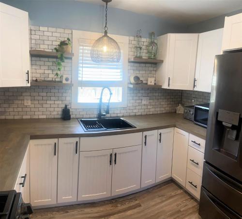 a kitchen with white cabinets and a sink and a window at Two level, 2-Bedrm, 1 ½ Bathrm. in Seaside Heights