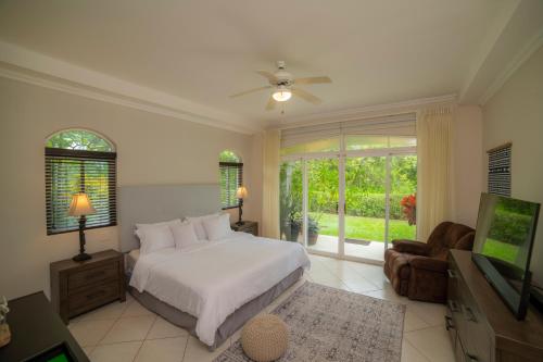 1 dormitorio con 1 cama y TV en Los Suenos Resort Colina 8F - 2 bdr by Stay in CR, en Herradura