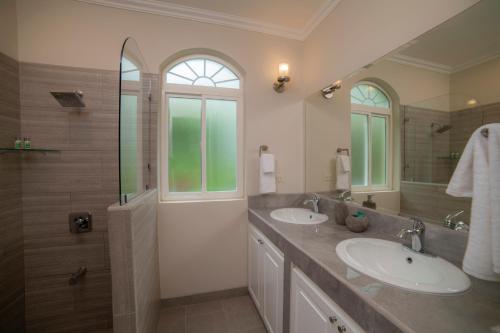 y baño con 2 lavabos y ducha. en Los Suenos Resort Colina 8F - 2 bdr by Stay in CR, en Herradura