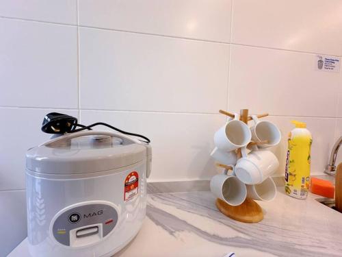 a toaster sitting on a kitchen counter with mugs at 12pax（free wifi）@星愿@Star WISH homestay in Labu