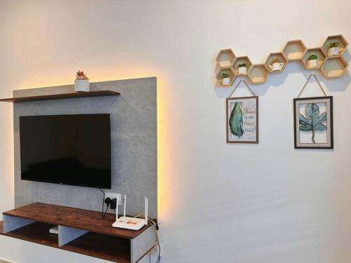 a living room with a flat screen tv and a shelf at 12pax（free wifi）@星愿@Star WISH homestay in Labu