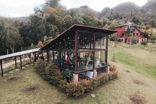a small building with people in it on a field at Cabanas Villa Helena in Guatavita