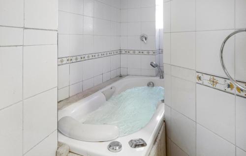 een badkamer met een bad gevuld met blauw water bij 3 Bedroom Stunning Apartment In Rapolano Terme in Rapolano Terme