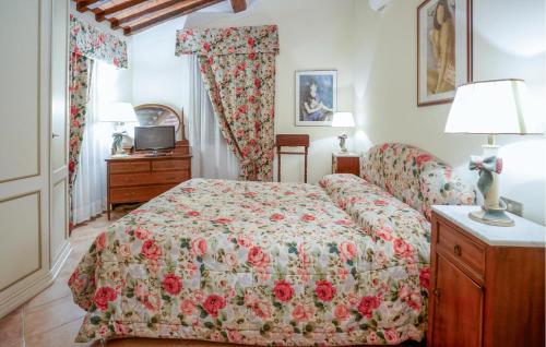 een slaapkamer met een bed met een bloemenbed bij 3 Bedroom Stunning Apartment In Rapolano Terme in Rapolano Terme