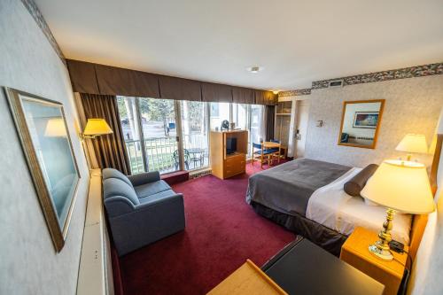 a hotel room with a bed and a balcony at Bow View Lodge in Banff