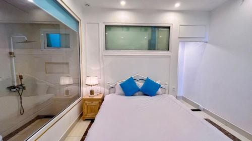 a small white bedroom with a bed and a shower at Da Lat Mom House in Ấp Kim Thạch