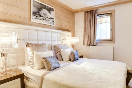 a bedroom with a large white bed with pillows at Résidence Carre Blanc - 3 Pièces pour 4 Personnes 424 in Courchevel