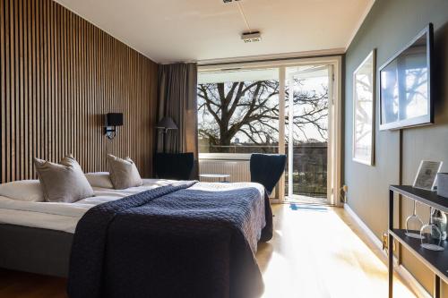 ein Hotelzimmer mit einem Bett und einem großen Fenster in der Unterkunft Albert Kök Hotell & Konferens in Trollhättan
