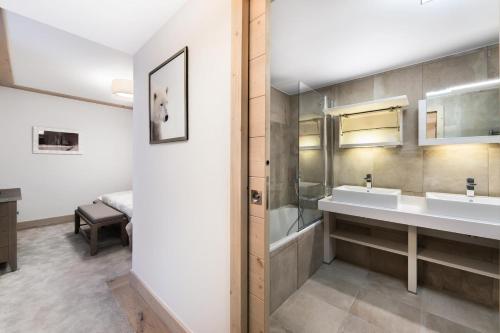 een badkamer met 2 wastafels en een bad bij Résidence Carre Blanc - 3 Pièces pour 6 Personnes 394 in Courchevel