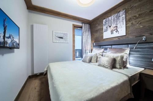 a bedroom with a large bed and a window at Résidence Carre Blanc - 3 Pièces pour 6 Personnes 464 in Courchevel