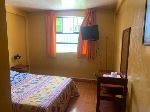 1 dormitorio con cama, ventana y TV en Hostal Residencial La Esmeralda, en Lima