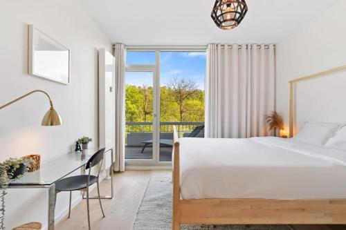 a bedroom with a bed and a desk and a window at Designed Apt w Pool in Dommeldange in Luxembourg