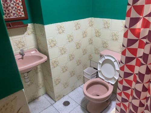 a bathroom with a pink toilet and a sink at Hostal Residencial La Esmeralda in Lima