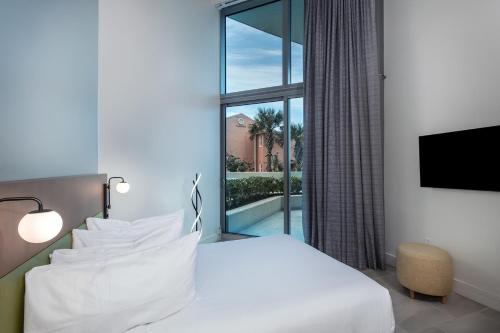 um quarto de hotel com uma cama e uma grande janela em Max Beach Resort em Daytona Beach