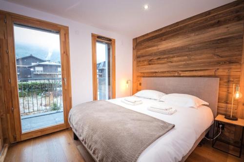 een slaapkamer met een groot bed en een groot raam bij Résidence Androsace Du Lyret - 2 Pièces pour 2 Personnes 564 in Chamonix-Mont-Blanc