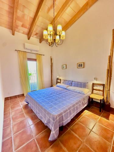 a bedroom with a bed and a chandelier at Finca Ses Barraques in Manacor
